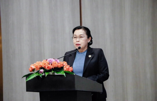 WORKSHOP ON LOCAL CURRENCY PROMOTION BETWEEN LAO PDR AND VIETNAM - Ảnh 1. A person standing at a podium with a microphone Description automatically generated
