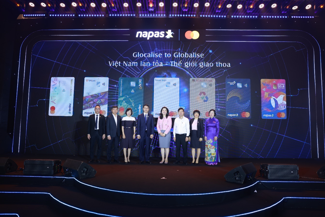 Chính thức ra mắt Thẻ đồng thương hiệu đầu tiên giữa NAPAS, Mastercard và các ngân hàng tại Việt Nam- Ảnh 2. A group of people standing on a stage AI-generated content may be incorrect.